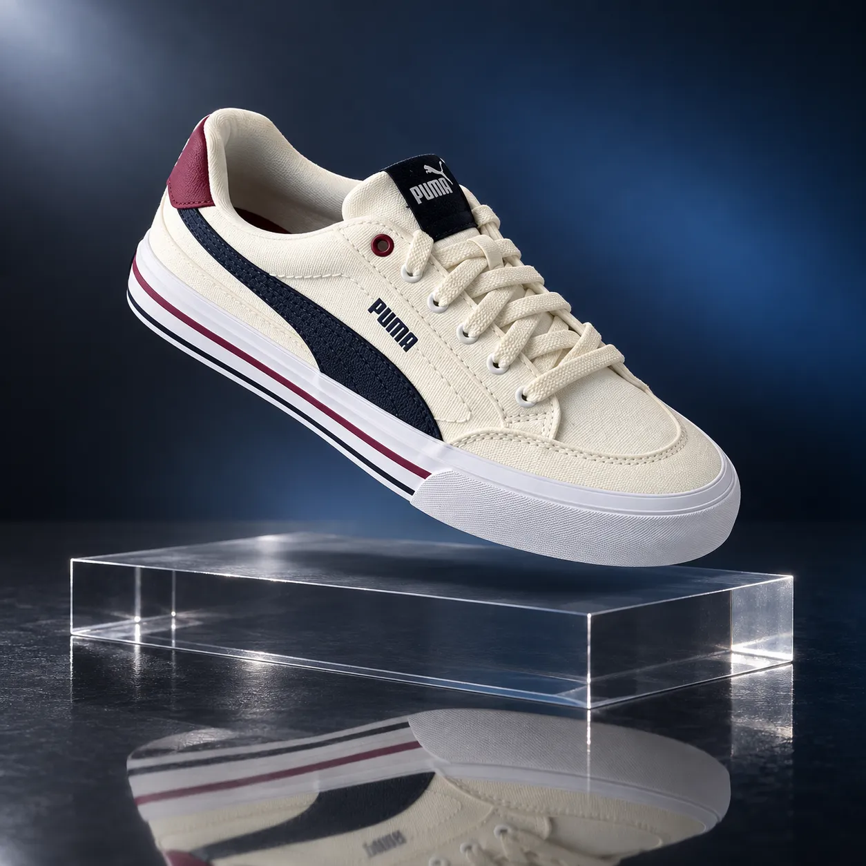 A cream Puma sneaker floating above a clear acrylic pedestal with a glossy reflection on a dark blue gradient background