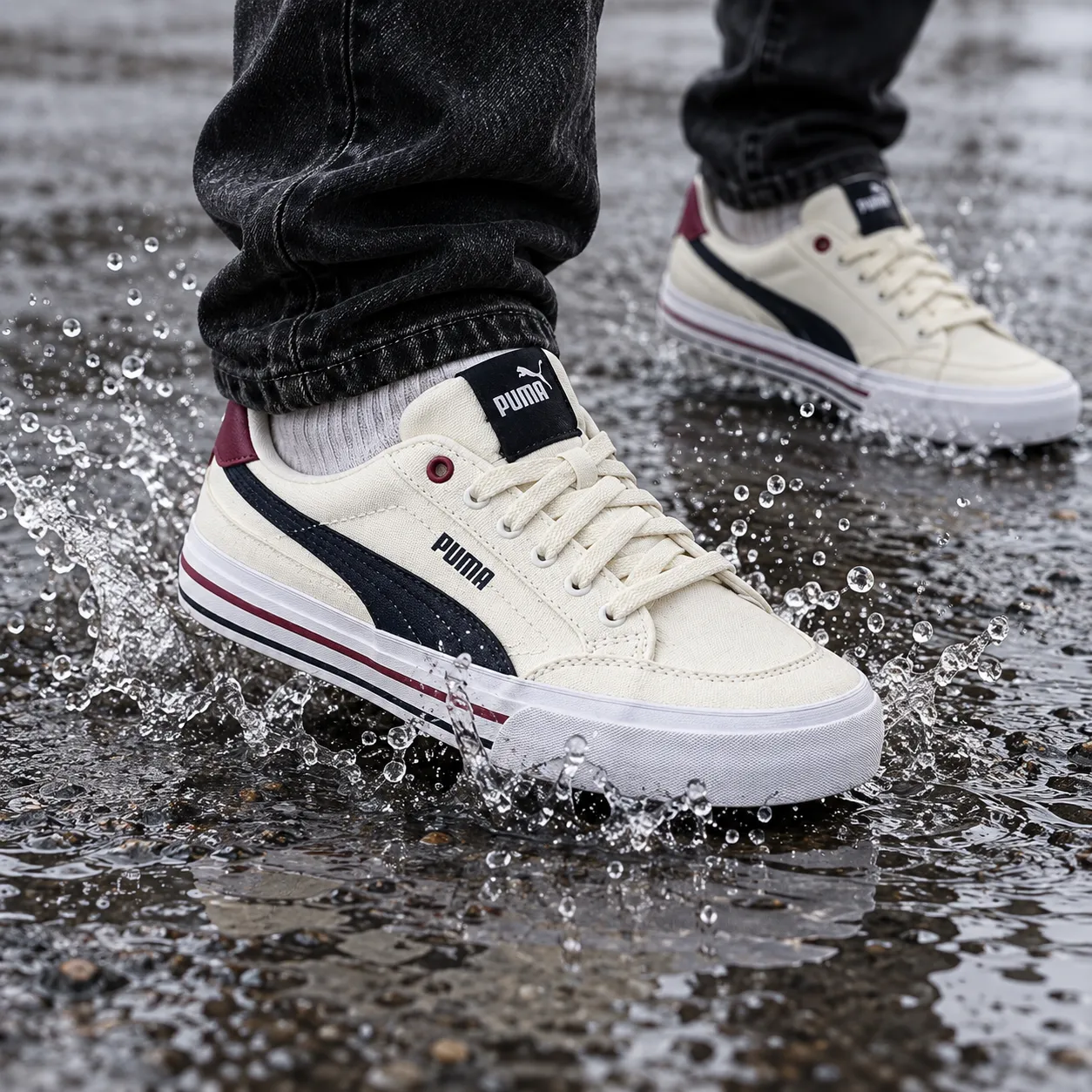 A sneaker stepping into a shallow puddle on wet asphalt with water droplets frozen mid-splash