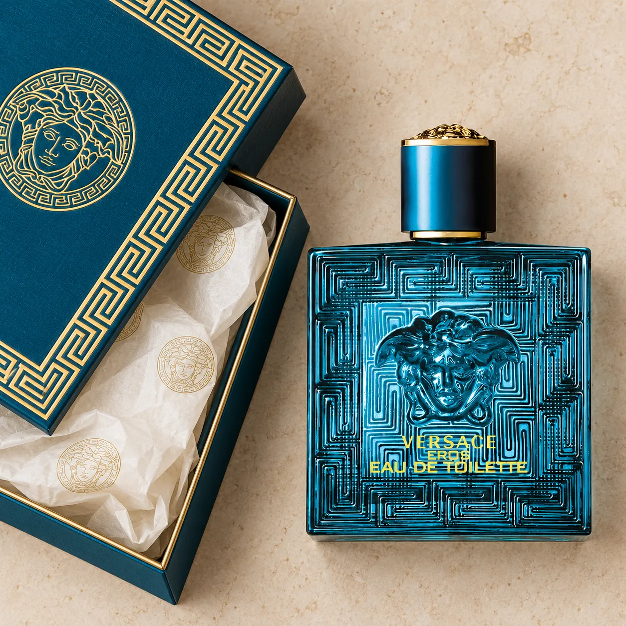 An overhead flat-lay of a perfume bottle beside its open packaging box and tissue paper